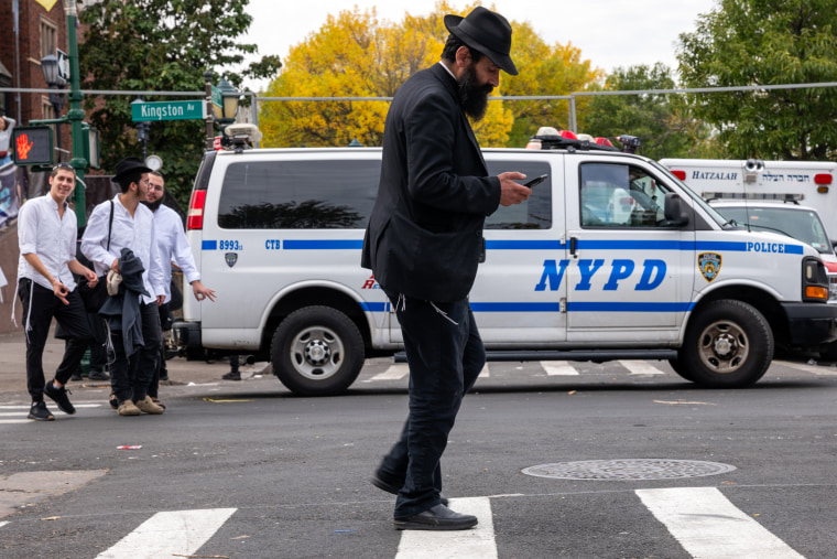 Image: A resident walks past a New York Police Department patrol van in Brooklyn on Thursday. Some areas have increased security following the conflict in Israel and the Gaza Strip.