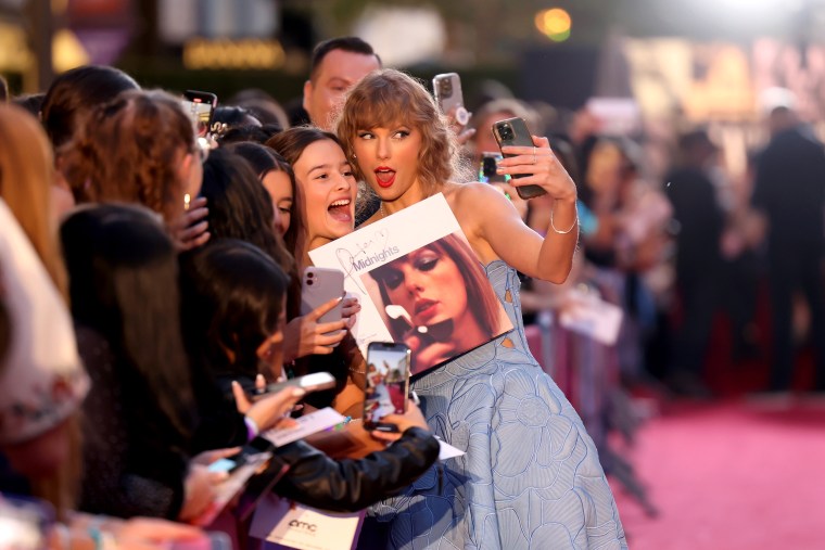 Image: Taylor Swift takes a selfie with a fan at the premiere for "Taylor Swift: The Eras Tour" in Los Angeles on Wednesday.