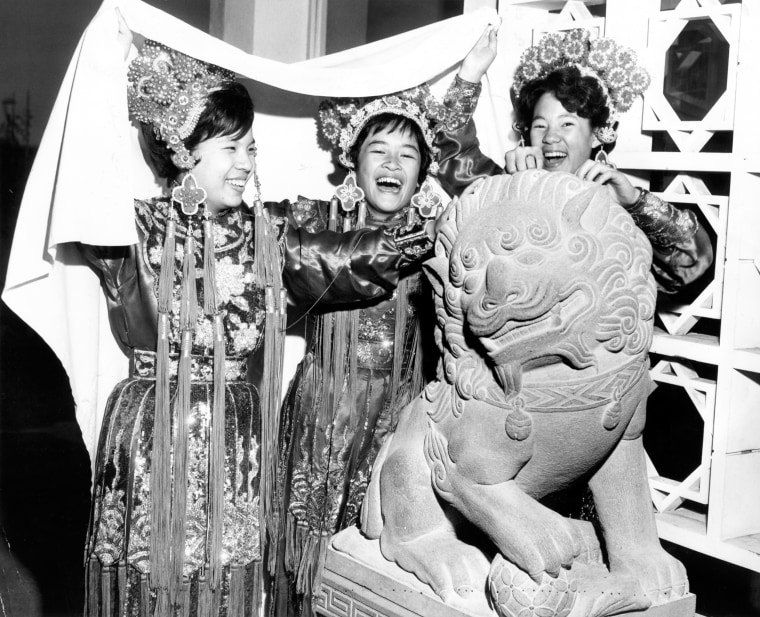 Team members Vickye Luke, Cheryl Chow and Wendee Ong touch a lion’s head for good luck at a 1962 event.