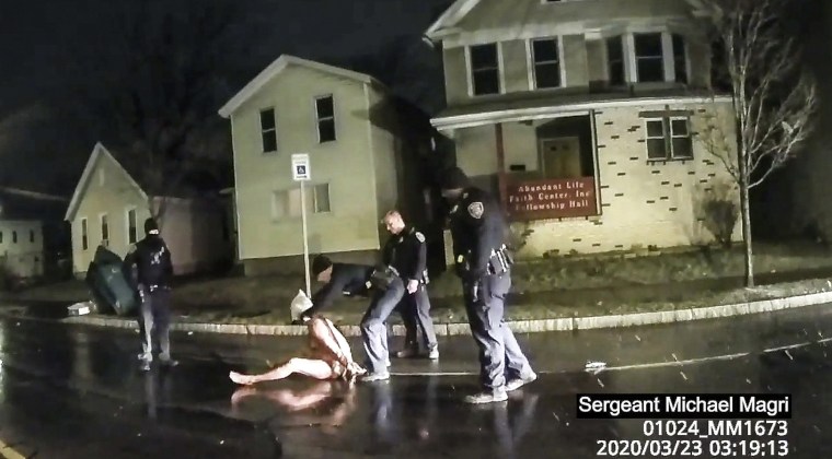 Image: A Rochester police officer as he puts a hood over the head of Daniel Prude
