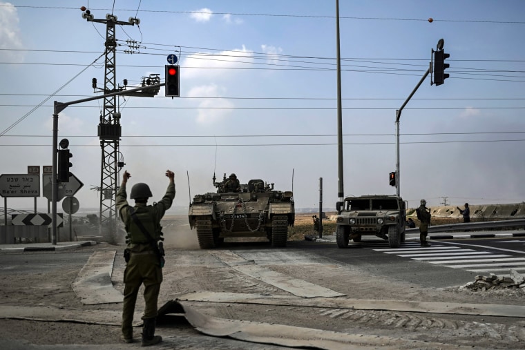 An Israeli soldier directs an approaching Puma APC moving near the Gaza border in southern Israel on Saturday.