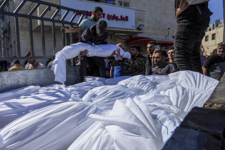 Sheet-covered bodies killed during an Israeli airstrike are loaded onto a truck outside al-Aqsa hospital in Deir el-Balah, Gaza