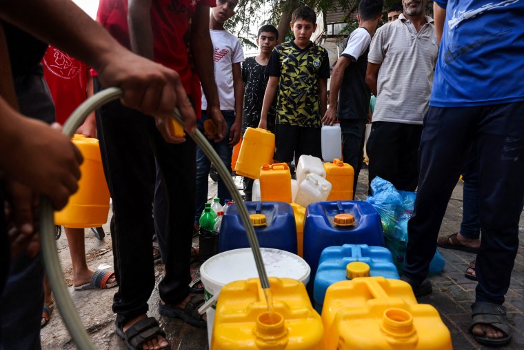Palestinians queue to refill on water in Rafah refugee camp, Gaza, on Oct. 14, 2023.