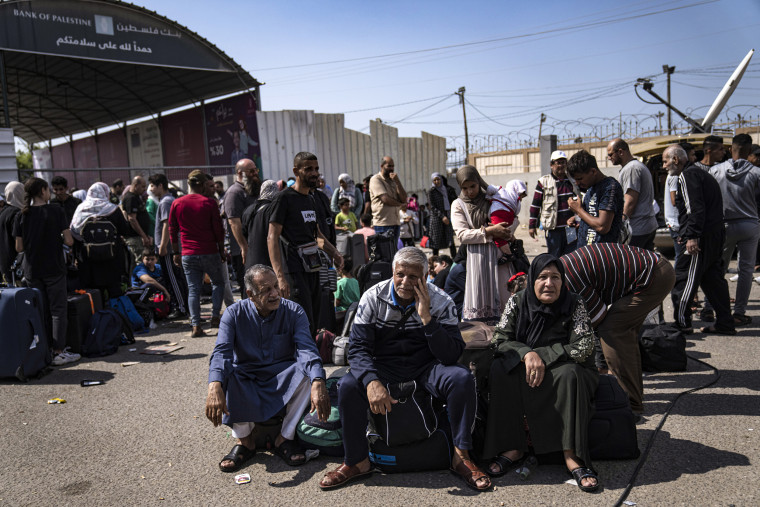 Image : Des Palestiniens attendent de passer la frontière égyptienne au poste frontière de Rafah, dans la bande de Gaza.