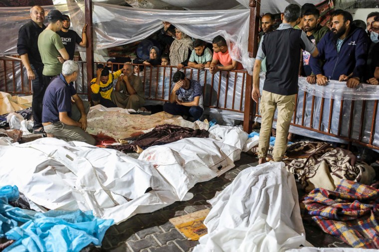 The bodies of the dead in a bombing on Al-Ahli hospital are gathered outside Al-Shifa hopsital, in Gaza.