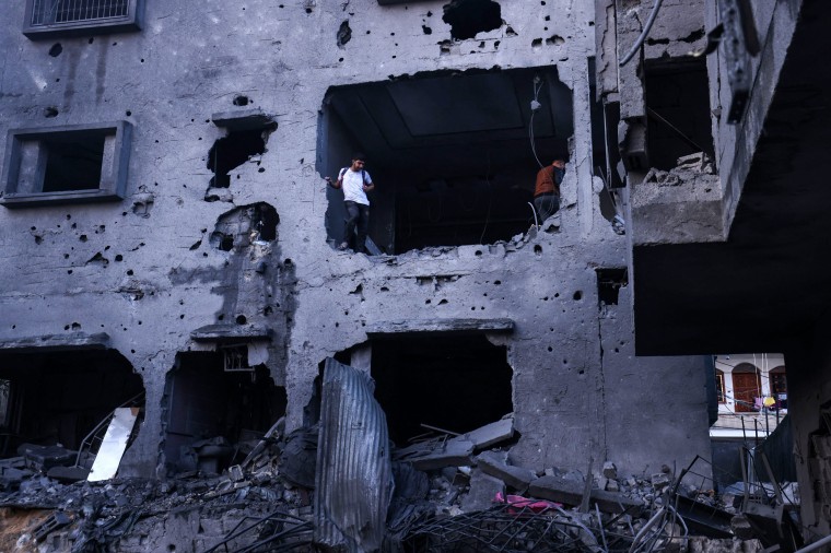 People inspect a damaged building after an Israeli airstrike on the Rafah refugee camp in Gaza.