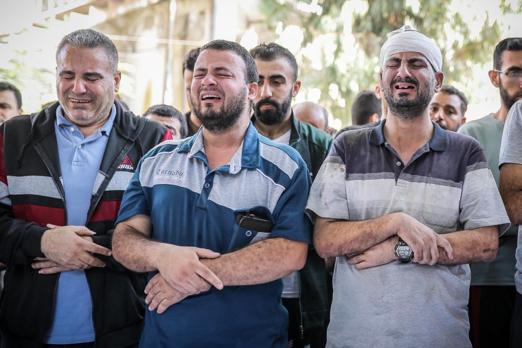 Relatives of the people who died in the explosion at Al-Ahli hospital mourn during a funeral ceremony in Gaza City.
