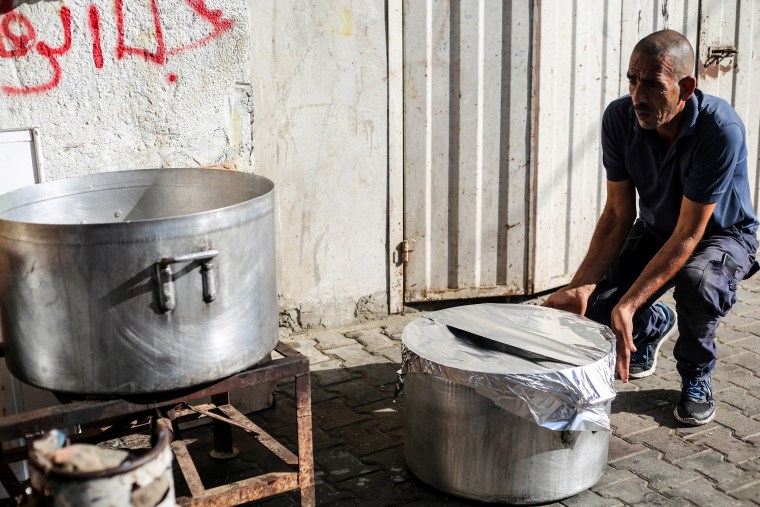 A cook prepares food for displaced people, whose homes were destroyed during Israeli raids, in Khan Yunis, Gaza.