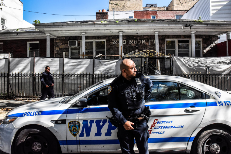 NYPD officers patrol in front of a synagogue in Brooklyn.