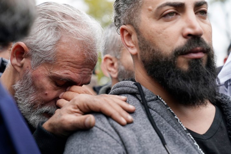 Wadea Al Fayoume's father, Oday Al Fayoume, right, and his uncle Mahmoud Yousef mourn at Wadea's grave in LaGrange