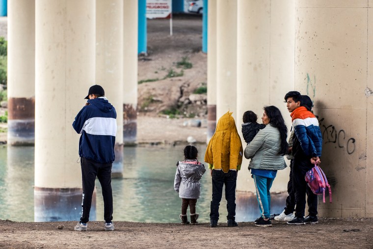 A family from Ecuador walks towards Border Patrol officers to seek asylum