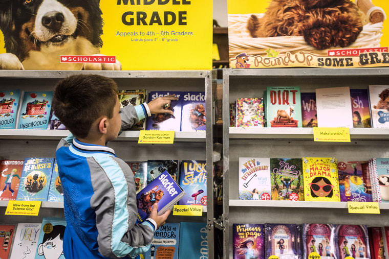 A boy picks out a book at a book fair