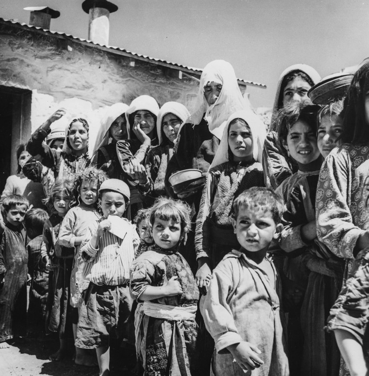 Palestinian refugees from Israel form a queue by the food tent in their camp in Amman, Jordan in 1955.