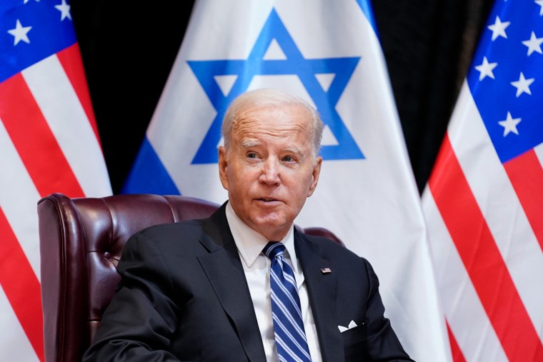 Joe Biden sits in front of Israel and U.S. flags. 