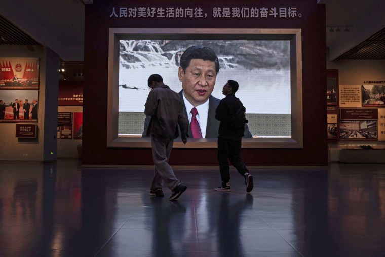 Visitors pass a video screen showing Chinese President Xi Jinping at the museum of the Communist Party of China in Beijing on Oct. 19, 2023. 