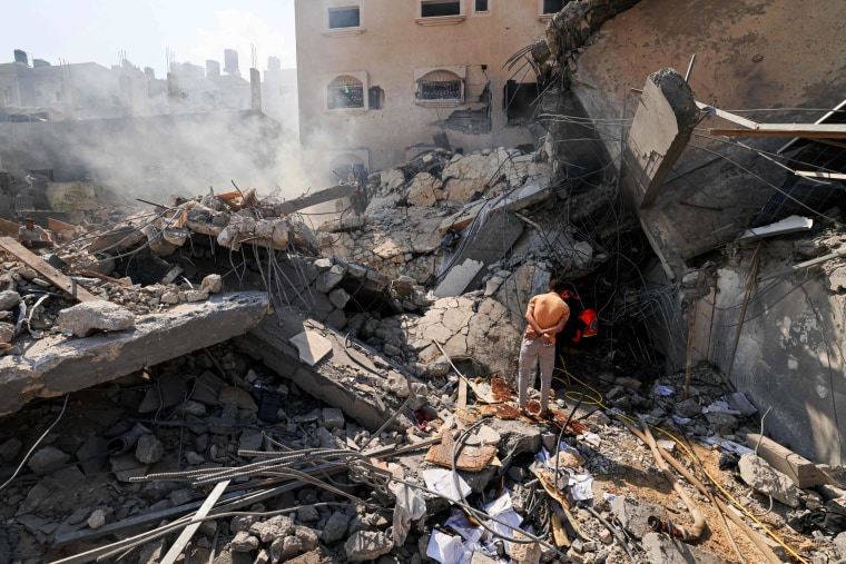 Palestinians look for survivors among the rubble of a collapsed building