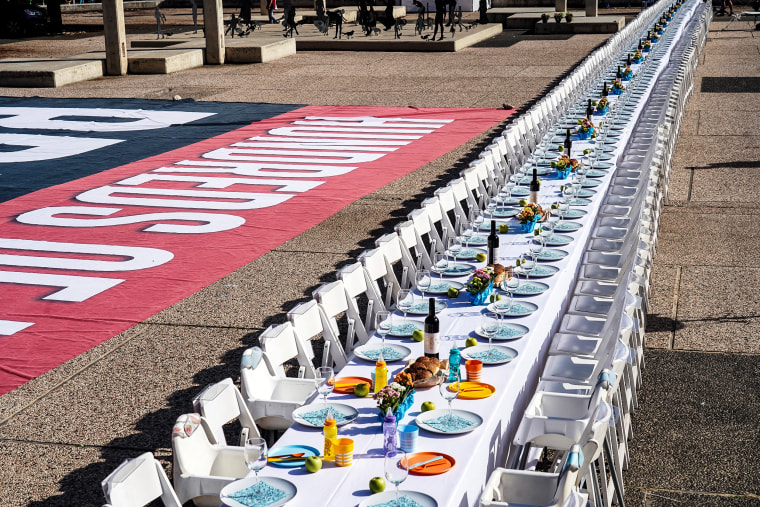 A dinner table is set with empty chairs that symbolically represent hostages and missing people with families that are waiting for them to come home, following a deadly infiltration by Hamas gunmen from the Gaza Strip, in Tel Aviv