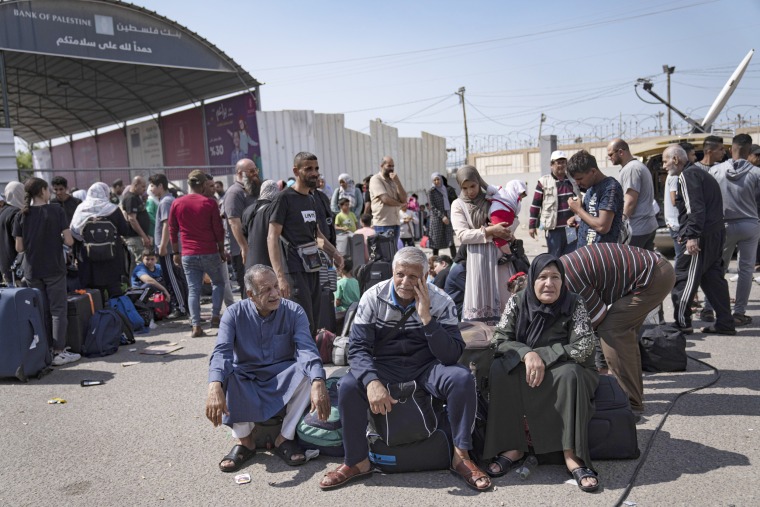 Palestinians wait to cross into Egypt at the Rafah border crossing in the Gaza Strip on Monday, Oct. 16, 2023. 