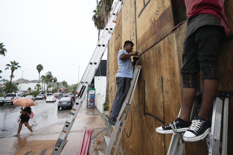 Employees cover the windows of a souvenirs store ahead of Hurricane Norma