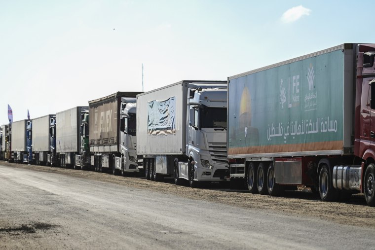 Aid convoy trucks loaded with supplies stands in front of the Rafah border crossing between Egypt and the Gaza Strip on Oct. 20, 2023.