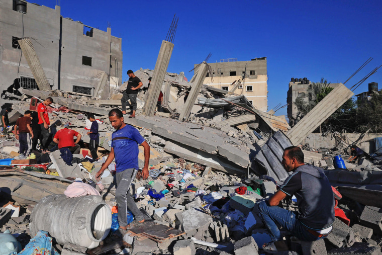 People search the rubble of a destroyed building in Rafah in the southern Gaza Strip on Oct. 21, 2023. 
