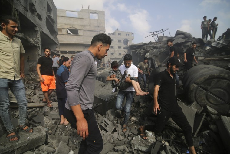 A Palestinian carries a child pulled out of a building hit in the Israeli bombardment of the Gaza Strip in Rafah, Sunday, Oct. 22, 2023.