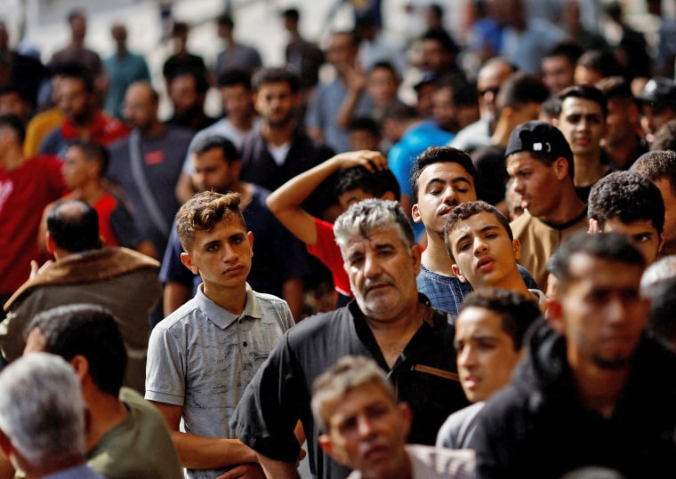 Palestinians queue to buy bread, amid shortages of food supplies and fuel, in Khan Younis