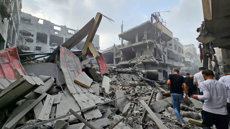 Palestinians inspect the site of Israeli strikes in the northern Gaza Strip on Oct. 23, 2023. 