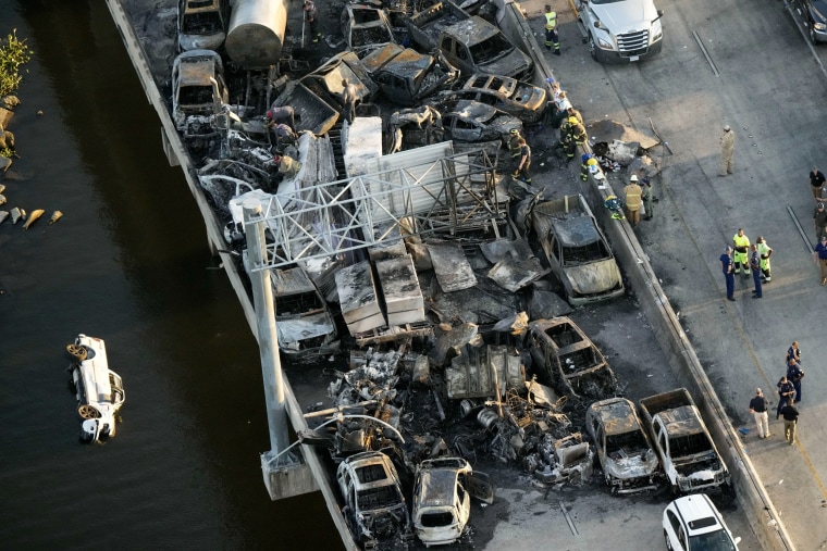 Responders near wreckage in the aftermath of a multi-vehicle pileup on I-55  in Manchac, La., Oct. 23, 2023. A “superfog” of smoke from south Louisiana marsh fires and dense morning fog caused multiple traffic crashes involving scores of cars.