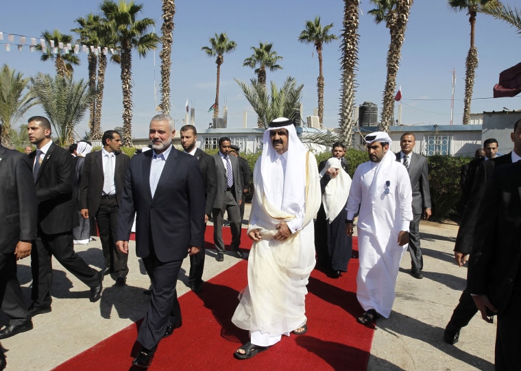 Gaza's Hamas Prime Minister Ismail Haniya, center left, walks alongside Qatari Emir Sheikh Hamad bin Khalifa al-Thani during a welcome ceremony