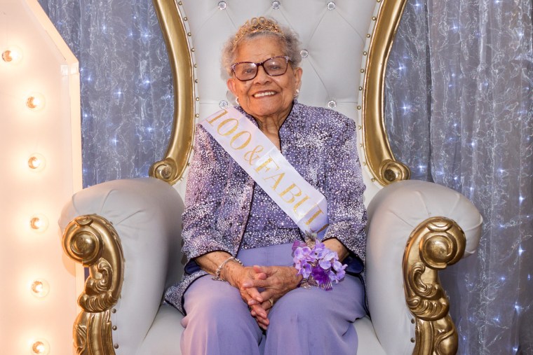 Elizabeth Eley sits on a chair with sash that reads,"100 & fabulous"