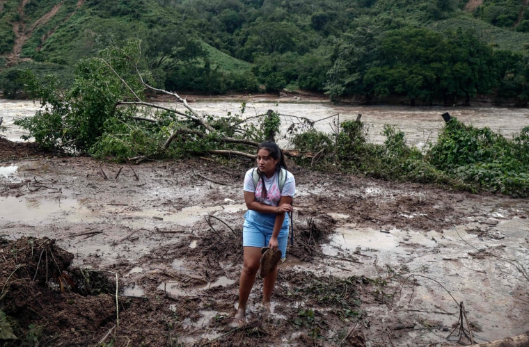 A woman stands in mud and debris in the Kilometro 42 community, near Acapulco, Mexico