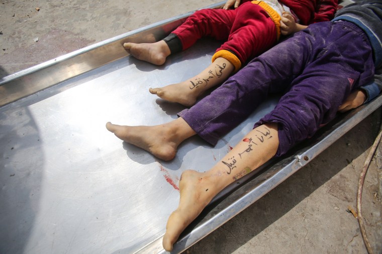 The bodies of children from the Nateel family with their names, Hani, left, and Layan, written on their legs by their parents to help in identification lie in the morgue of a hospital in Deir el-Balah, Gaza.