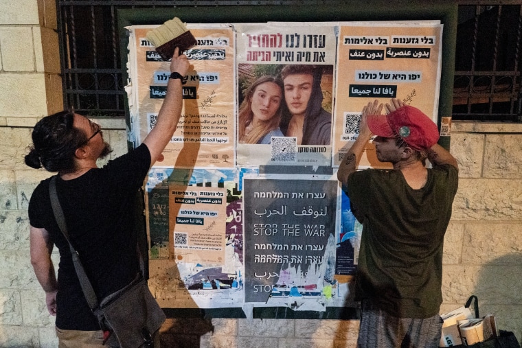 Members of the Arab-Jewish Partnership Guard in Tel-Aviv-Jaffa put up anti-war posters in Jaffa, Israel.