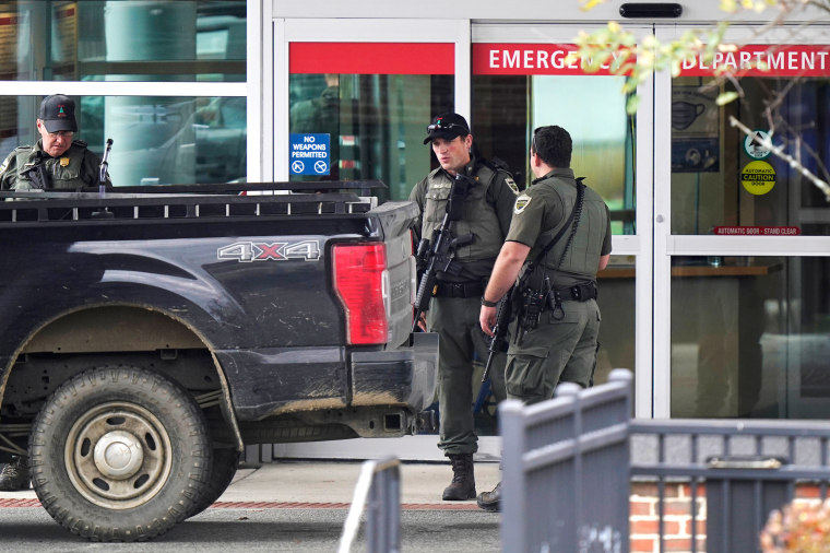 Law enforcement officers near an emergency department entrance at Central Maine Medical Center during an active shooter situation, in Lewiston
