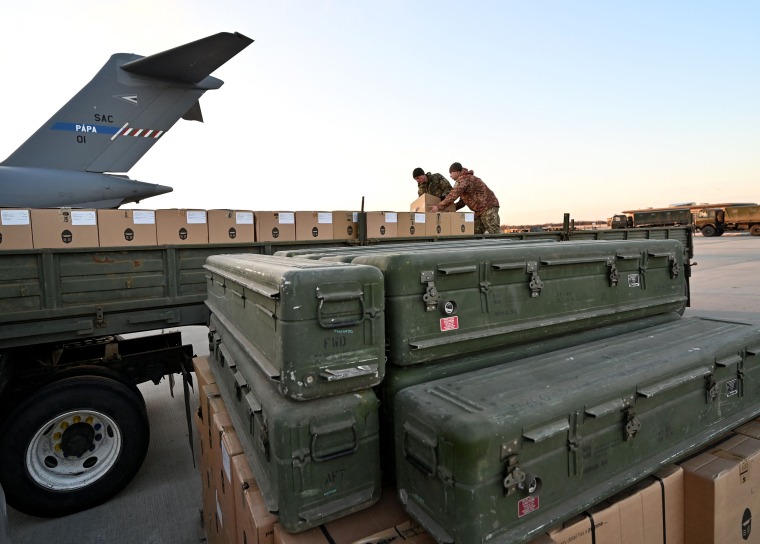 Ukrainian Military Forces load a flat bed truck with boxes at the airport in Kyiv.