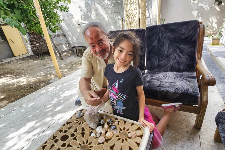 Hamed Alhayek, 72, sits with his granddaughter Alya Alhayek going through shells she picked up from the beach in their home in the northern part of the Gaza strip this past summer.