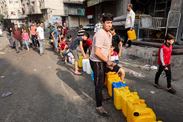 People queue for clean water in Gaza City.