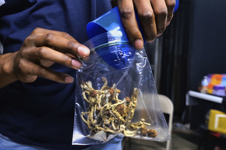 A vendor bags psilocybin mushrooms at a cannabis marketplace