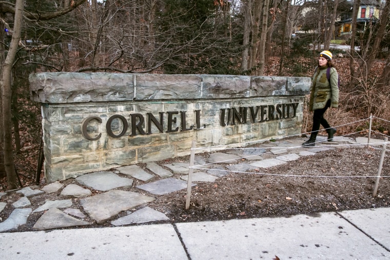 A woman walks by a Cornell University sign on the Ivy League school's campus in Ithaca, N.Y., last year. 