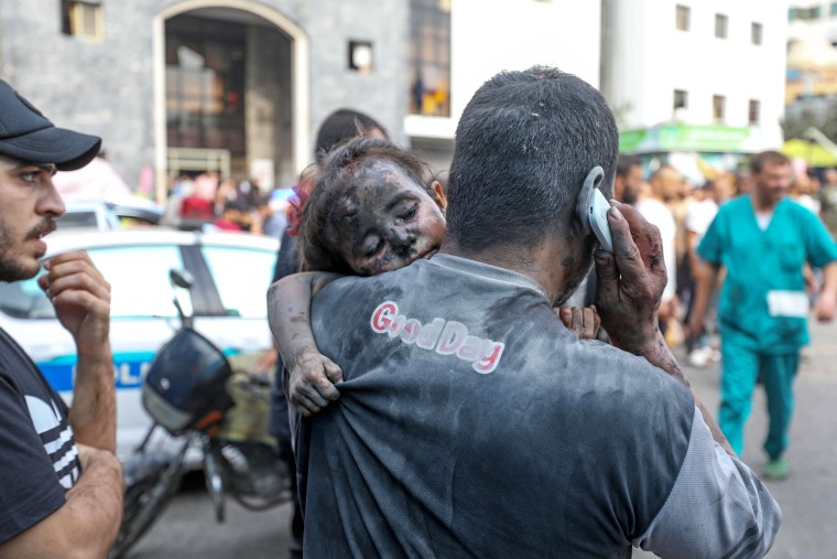 Palestinian man carries injured girl to hospital in Gaza City. 