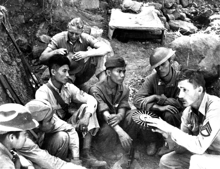 A U.S. Marine speaks to a group of Filipino soldiers on Corregidor Island in the Philippines, in May 1942.