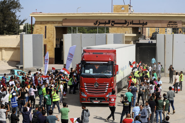 Egyptian aid workers celebrate as a truck crosses back into Egypt through  of the Rafah Border crossing on Oct. 21, 2023. 