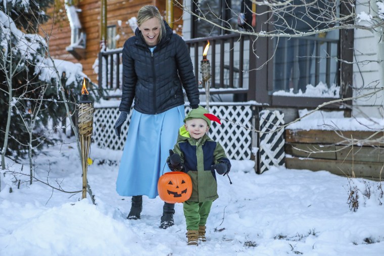 Katie Brandl follows Duke, 2, on the hunt for treats during a trick-or-treat event Monday, Oct. 30, 203, in Minturn, Colo. 