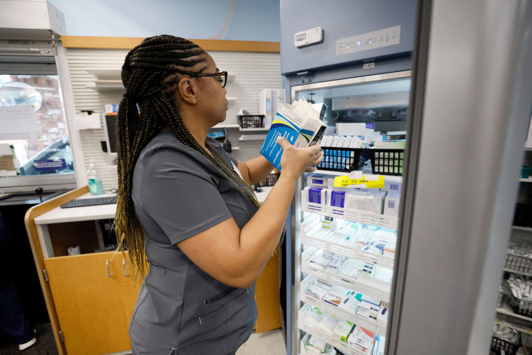 CVS pharmacist Estrella Clemons pulls vaccines from a fridge