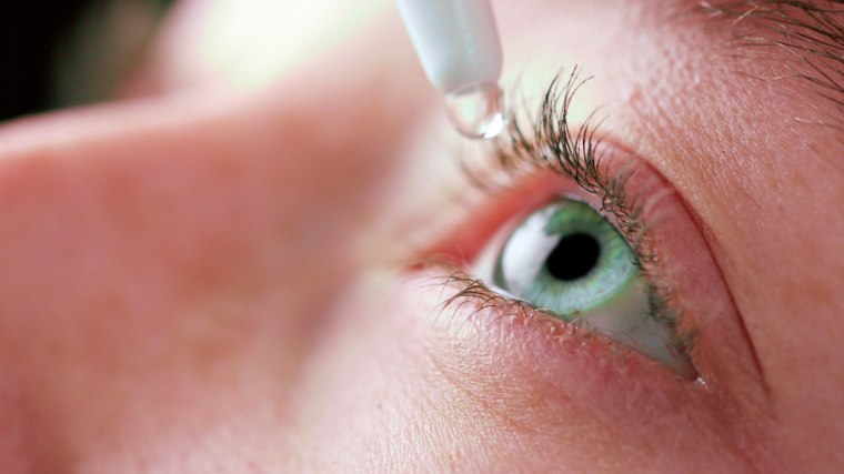Close-up of person using eyedrops.