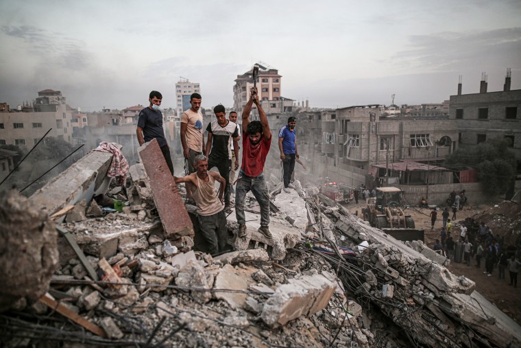 Civilians conduct a search and rescue operation under the debris of destroyed building following Israeli attacks on the Nuseirat Camp in Deir al Balah, Gaza on Oct. 31, 2023. 