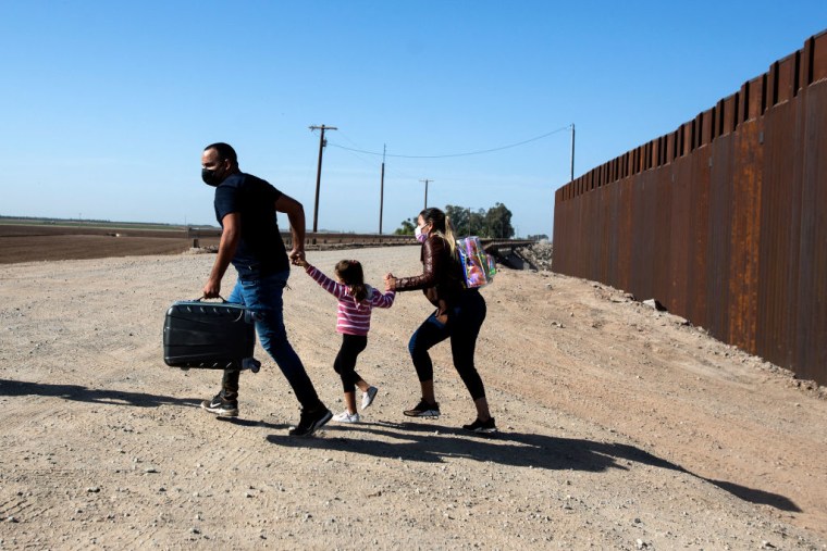 Una familia de migrantes de Cuba corre al pasar el muro que separa la frontera sur con México  para entregarse a las autoridades estadounidenses en una foto de archivo de 2021 en Yuma, Arizona.