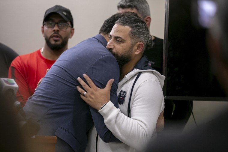 State Rep. Abdelnasser Rashid embraces Oday Al-Fayoume, father of Wadea Al-Fayoume, 6, at the Muslim Community Center on Chicago's Northwest Side on Sunday.