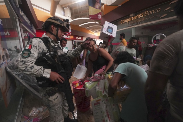 Un soldado de la Guardia Nacional Mexicana intenta detener los saqueos en un centro comercial después de que el huracán Otis arrasara Acapulco, México.